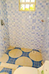 a bathroom with a toilet and a blue tiled floor at Gerly Homes Hotel & Restaurant in Kakamega