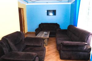 a living room with a couch and couches and a table at Gerly Homes Hotel & Restaurant in Kakamega
