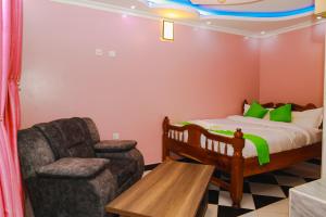 1 dormitorio pequeño con 1 cama y 1 silla en Gerly Homes Hotel & Restaurant, en Kakamega