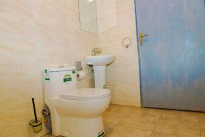 a bathroom with a toilet and a sink at Gerly Homes Hotel & Restaurant in Kakamega