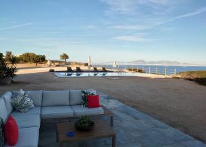um sofá sentado num pátio ao lado do oceano em My Way Kavos Villa em Agia Marina