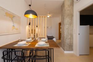 comedor con mesa de madera y sillas en FLORIT FLATS - The Pitiusas Rooms, en Valencia