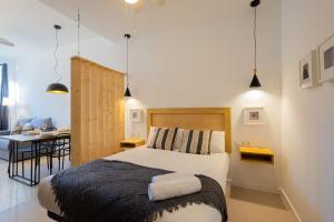 a bedroom with a bed and a desk in a room at FLORIT FLATS - The Pitiusas Rooms in Valencia