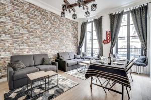 uma sala de estar com uma parede de tijolos em 138 Suite Wizman - Superbe Appartement à Paris em Paris