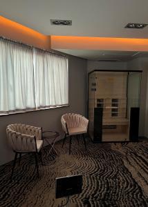 een woonkamer met 2 stoelen en een tafel bij Hotel River Park in Cluj-Napoca