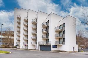 a white building with balconies on a street at Prague City Residence in Prague