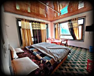a bedroom with a bed and a table and windows at Forest inn pahalgam in Anantnāg