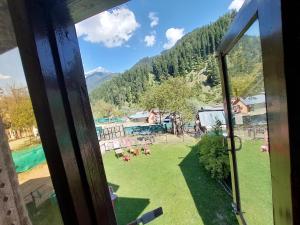 una vista da una finestra di un gruppo di persone in un campo di Forest inn pahalgam a Anantnāg