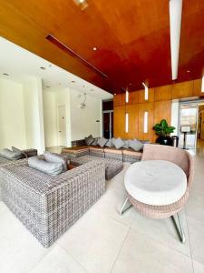 - un salon avec des canapés et une table dans l'établissement Two Bedroom Condo in BGC with Balcony, Sauna, & Pool, à Manille