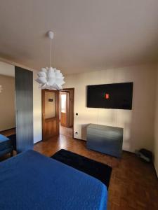 a bedroom with a blue bed and a tv at La Dolce Vita, appartamento al centro di Biella in Biella
