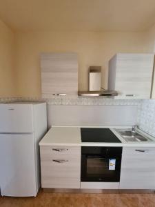a kitchen with white cabinets and a stove top oven at La Dolce Vita, appartamento al centro di Biella in Biella