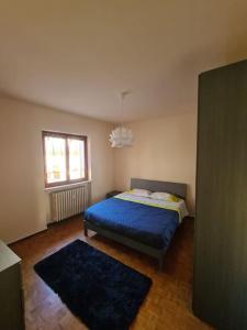 a bedroom with a blue bed and a window at La Dolce Vita, appartamento al centro di Biella in Biella