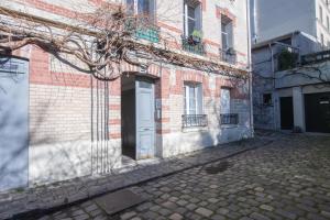 um edifício de tijolos com uma porta branca numa rua em Cosy and very nice flat with open view on a parc em Paris