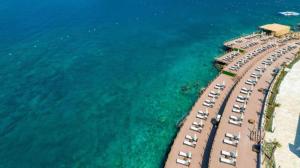 an aerial view of a beach with chairs and the water at Lures Hotel in Kalkan