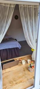 Schlafzimmer mit einem Tisch und einem Bett mit Vorhängen in der Unterkunft Old Farm in Idschewan