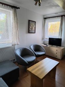 salon z 2 krzesłami i stołem w obiekcie Bogdanówka w Supraślu