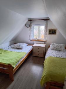 2 łóżka pojedyncze w pokoju z oknem w obiekcie Bogdanówka w Supraślu