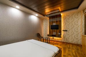FabHotel Le Masrana Inn tesisinde bir odada yatak veya yataklar