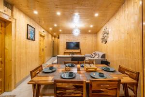 a wooden dining room with a table and a couch at FabHotel Le Masrana Inn in Mussoorie