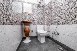 a bathroom with a toilet and a vase in it at FabHotel Le Masrana Inn in Mussoorie