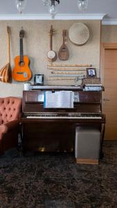 un piano en una sala de estar con guitarras en la pared en Ers Life Hotel en Estambul