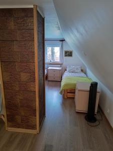ein Schlafzimmer mit einem Bett und einer Wand in der Unterkunft Bogdanówka in Supraśl