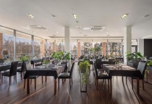 a dining room with tables and chairs and large windows at Hotel Moran & SPA in Powidz