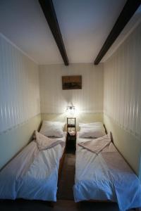 2 łóżka pojedyncze w pokoju z lampką w obiekcie Hellényi apartmanok w mieście Harkány