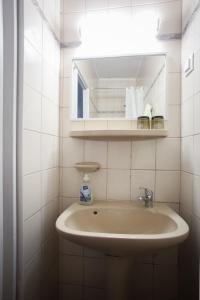 W łazience znajduje się umywalka i lustro. w obiekcie Hellényi apartmanok w mieście Harkány