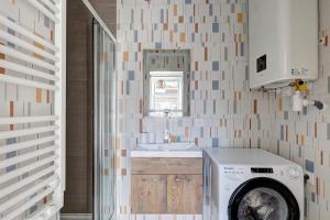 ein Badezimmer mit einer Waschmaschine und einem Waschbecken in der Unterkunft 870 Suite Trefle - Superb apartment in Montreuil