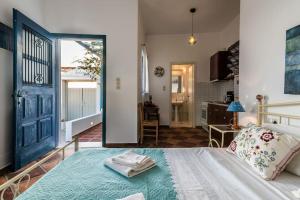 a bedroom with a bed with a blue door at Melisses Sea View Studio in Plaka Milou