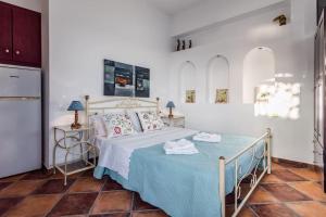 a bedroom with a bed with a blue blanket at Melisses Sea View Studio in Plaka Milou