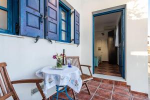 a room with a table and chairs and a door at Melisses Sea View Studio in Plaka Milou