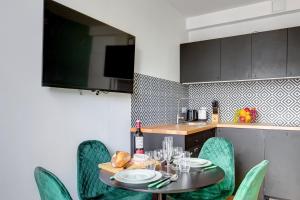 eine Küche mit einem Tisch und Stühlen mit Tellern und Gläsern in der Unterkunft 870 Suite Trefle - Superb apartment in Montreuil