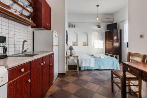 a kitchen with a sink and a table in a room at Melisses Sea View Studio in Plaka Milou