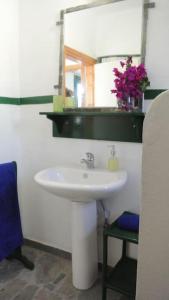 a bathroom with a white sink and a mirror at Charming Cottage on the sea turtle beach in Apolakkiá
