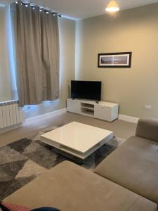 a living room with a tv and a coffee table at Beautiful city centre apartment. in Salisbury