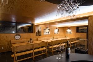 a restaurant with wooden tables and chairs and a chandelier at Penzion Aurelia Donovaly in Donovaly