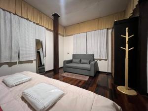 ein Schlafzimmer mit einem Bett, einem Kreuz und einem Stuhl in der Unterkunft Allred Hostel Chiangmai in Chiang Mai