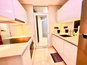 eine weiße Küche mit einem Waschbecken und einem Fenster in der Unterkunft Vortex klcc in Kuala Lumpur