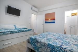 1 dormitorio con 1 cama y TV de pantalla plana en Agio Apartments Diamante - Bilocale, en Diamante