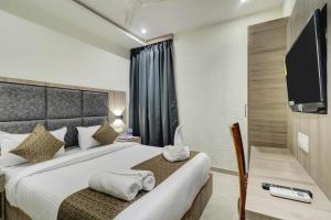 a hotel room with a bed and a flat screen tv at Hotel Sion Fort in Mumbai