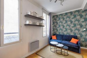 a living room with a blue couch and a window at 316 Suite BIOT 6 - Superb apartment in Paris in Paris