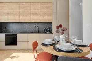 a kitchen with a wooden table with chairs and a dining room at Fresh & Stylish Apartments in Poznań with Parking & Balcony by Renters in Poznań