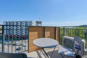 a balcony with a table and chairs and a view of a city at Fresh & Stylish Apartments in Poznań with Parking & Balcony by Renters in Poznań
