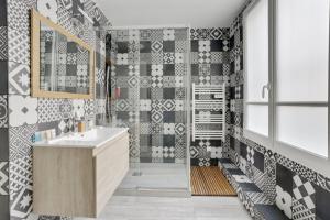 bagno con lavandino e doccia con piastrelle bianche e nere di 215 Suite Esprit Nature - Superb apartment a Parigi