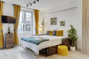una camera da letto con un grande letto con tende gialle di 215 Suite Esprit Nature - Superb apartment a Parigi