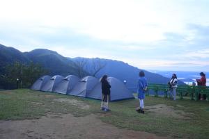 a group of people standing in front of tents at Campper Eagle View Point Vagamon in Idukki