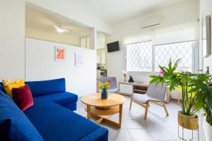ein Wohnzimmer mit einem blauen Sofa und einem Tisch in der Unterkunft Best spot apartment in Athens in Athen