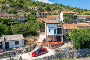 a red car parked in front of a house at Villa Lisinj apartments in Dapčevići